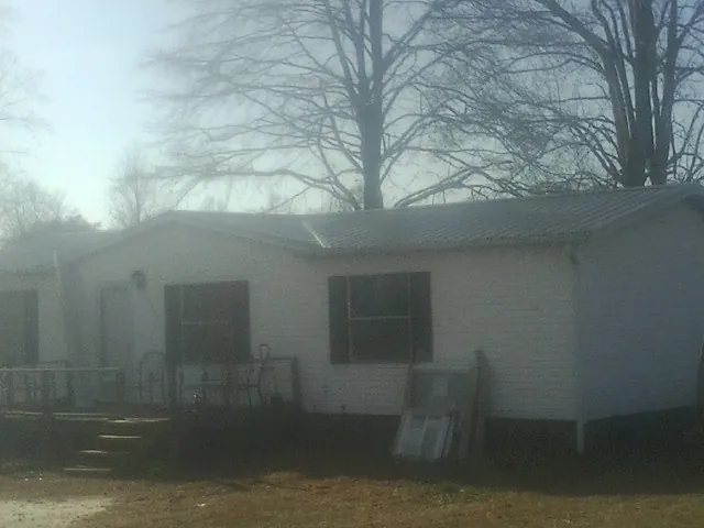 New metal roof on a white painted brick home on a foggy morning in Carson